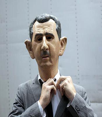 A man dressed as Syrian President Assad adjusts his costume ahead of a protest in New York. (R)