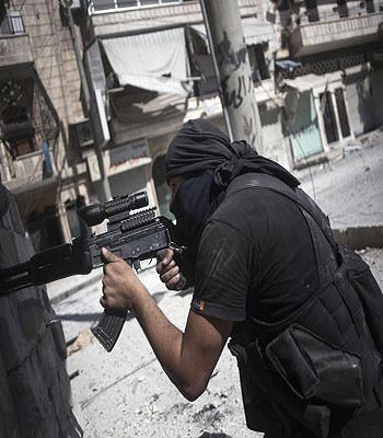 A Free Syrian Army fighter fires at Syrian Army positions during a clash in Aleppo, Syria, Wednesday, Sept. 26, 2012. (AP)