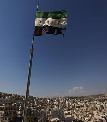 In this Tuesday, June 12, 2012 file photo, a Syrian revolutionary flag waves on top of a building on the outskirts of Aleppo, Syria. (AP)