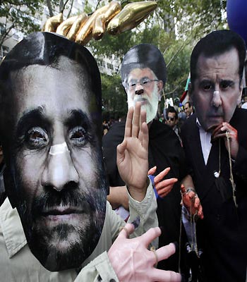 Men wearing masks of Mahmoud Ahmadinejad, Ayatollah Ali Khamenei, and Bashar al-Assad, participate in a protest outside the United Nations. (AP)