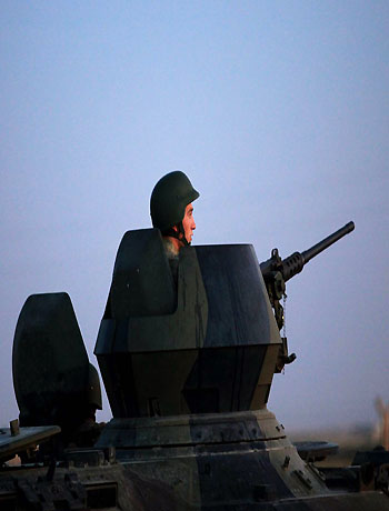 Turkish military stand near the Turkey-Syria border in Akcakale, Turkey, early Friday, Oct. 5, 2012. (AP)