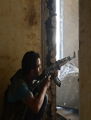 A Syrian rebel aims his weapon during clashes with government forces in the Saif al-Dawla district of the northern city of Aleppo on October 5, 2012. (AFP)