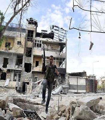 A Syrian rebel runs across a heavily damaged street to dodge sniper fire during clashes with government forces in the Saif al-Dawla district of the northern city of Aleppo. (AFP)