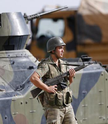 A Turkish soldier stands guard on the Turkish-Syrian border near the Akcakale border crossing. (R)