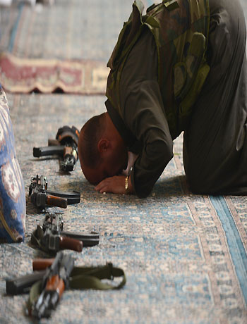 A Syrian rebel commander prays inside a damaged mosque during clashes with government force in the Saif al-Dawla district of the northern city of Aleppo, on October 9, 2012. (AFP)
