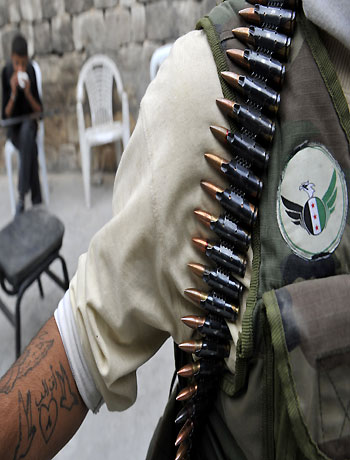 A Syrian opposition fighter stands near a post in the northern city of Aleppo on October 11, 2012. (AFP)