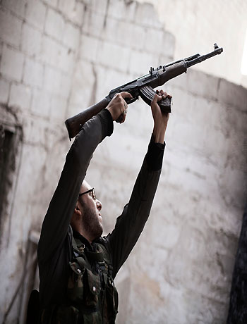 In this Wednesday, Oct. 10, 2012 photo, a Free Syrian Army fighter fires his weapon against Syrian Army positions in the Karmal Jabl district of Aleppo, Syria. (AP)
