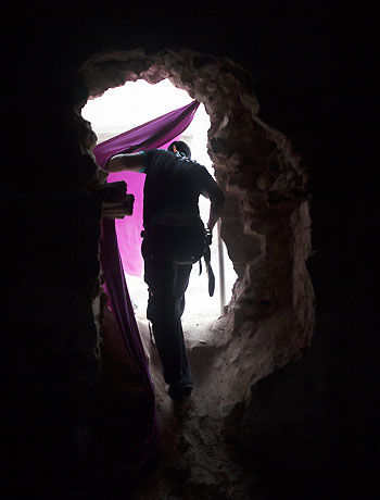 In this Wednesday, Oct. 10, 2012 photo, a Free Syrian Army fighter passes through a hole punched into a wall in the Karmal Jabl district in Aleppo, Syria. (AP)