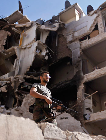 A member of the Free Syrian Army inspects damaged houses in Bustan al Basha in Aleppo city in northern Syria October 12, 2012. (Reuters)