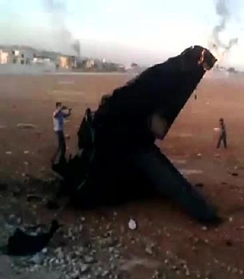 An image grab taken from a video uploaded on YouTube allegedly shows flames rising from the remains of a military fighter jet in the northern province of Aleppo. (AFP)