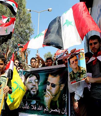 Syrian pro-government protesters wave a giant Syrian flags and hold pictures depicting Bashar al-Assad and Hezbollah’s Hassan Nassrallah, during a march in Beirut. (EPA)