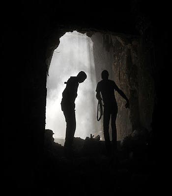Syrian rebels take cover during clashes with regime forces at the Umayyad Mosque in the old city of Aleppo hours before the Syrian army retook control of the complex. (AFP)