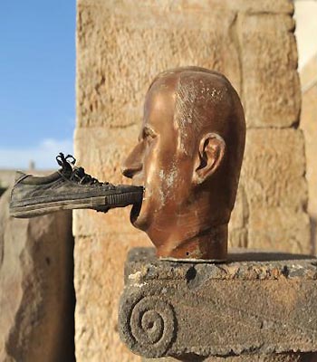 A shoe is seen glued to a statue of late Syrian president Hafez al-Assad, at the museum of Maaret al-Numan, in the northwestern Idlib province. (AFP)