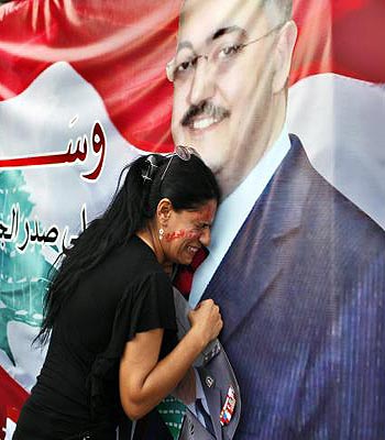 A woman mourns at a poster with an image of senior intelligence official Wissam al-Hassan during a protest against his killing, at Martyrs' square in downtown Beirut. (R)