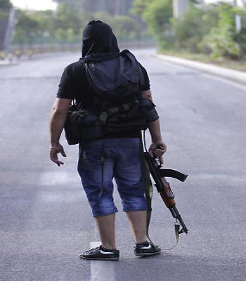 A Sunni gunman stands guard on an empty street leading to a Shiite neighborhood after overnight clashes that erupted between Sunni and Shiite gunmen, in Beirut, Lebanon. (AP)