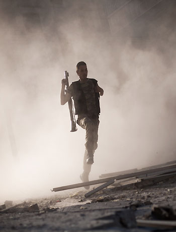 In this Friday, Sept 7, 2012 file photo, a Free Syrian Army fighter runs after attacking a tank with a rocket-propelled grenade during fighting in the Izaa district in Aleppo, Syria. (AP)
