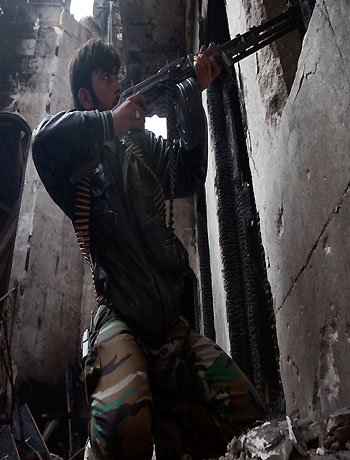 A rebel fighter fires his weapon against Syrian government forces in the Bab el-Adid district in Aleppo on October 23, 2012. (AFP)