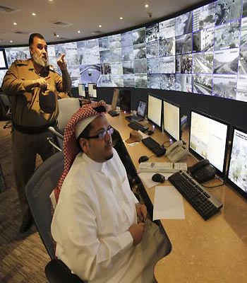 Saudi policemen monitor screens connected to cameras set up at places around the holy city of Mecca. (R)