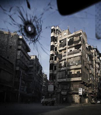 A general view taken from inside a bullet riddled car shows sunset in the battered eastern neighbourhood of Shaar in Syria's northern city of Aleppo. (AFP)
