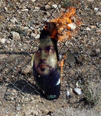 A picture of Hasan Nasrallah, is burned by a Free Syrian Army fighter for his support to Syrian President Bashar al-Assad, in Haram town , Idlib Governorate. (R)