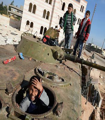 Syrian children play on a destroyed army tank in the northern Syrian town of Azaz . (AFP)