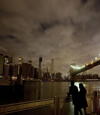 People stop along the Brooklyn waterfront to look at the Brooklyn Bridge and the Manhattan skyline. (AP)