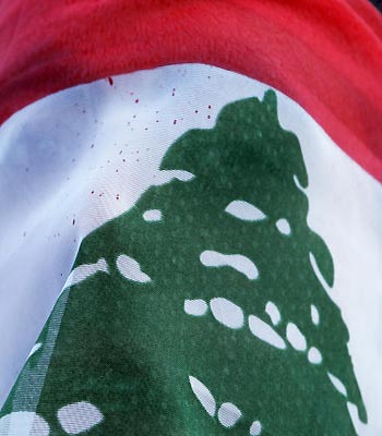 An anti-government protester covers his face with a Lebanese flag as he shouts slogans during a demonstration demanding the resignation of Lebanese Prime Minister Najib Mikati, in Beirut. (AP)