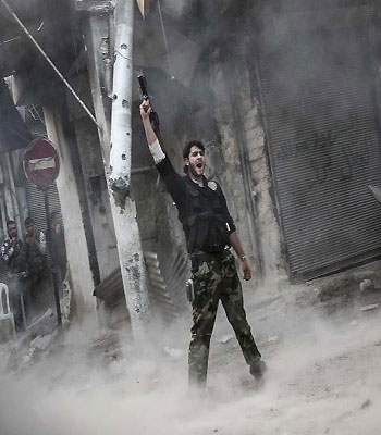 A rebel fighter claims for victory after he fires a shoulder-fired missile toward a building where Syrian troops loyal to President Bashar Assad are hiding in the Jedida district of Aleppo, Syria.(AP)