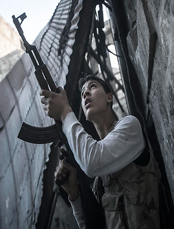 n this Saturday, Nov. 03, 2012 photo, a rebel fighter watches windows in an overlooking building as he awaits for loyalists to President Bashar Assad to appear during heavy fighting in the Jedida district of Aleppo, Syria. (AP)