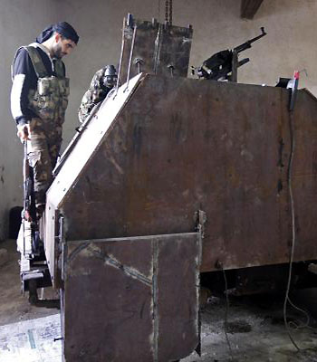 Free Syrian Army fighters stand by a homemade military vehicle called Sham 2 in Khan al-Assal area. (R)