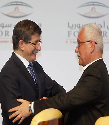 Turkish Foreign Minister Davutoglu congratulates new SNC leader Sabra during the meeting of the general assembly of the Syrian National Council in Doha. (R)