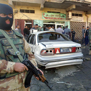 An Iraqi security members guard the site where a suicide car bomb detonated in Al-Mashtel district south east of Baghdad on Tuesday, 14 November 2005 (EPA)