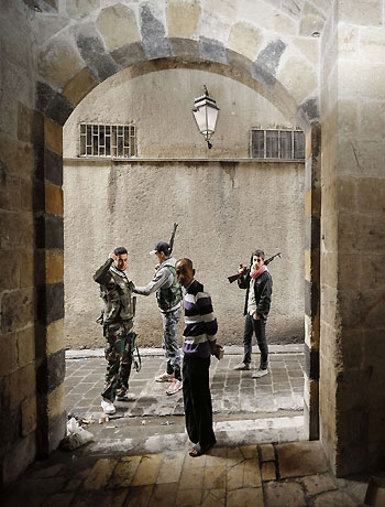 Syrian opposition fighters pass an old man as they patrol the northern city of Aleppo on November 11, 2012. (AFP)