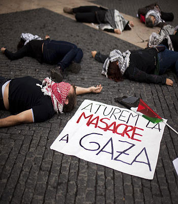 Activists lay on the ground next to a banner reading in Catalan "Stop the Massacre in Gaza" during a demonstration against Israel's attacks on Gaza, in Barcelona, Spain. (AP)