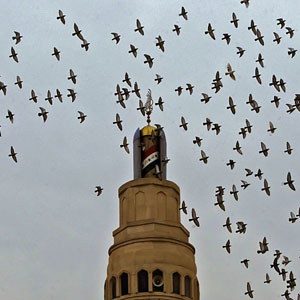 Pigeons fly over one of the minarets of Sunni Um al-Qura mosque in Baghdad, 16 November 2005. Iraq's government faced calls for an international enquiry into abuse at a secret prison in Baghdad (AFP)