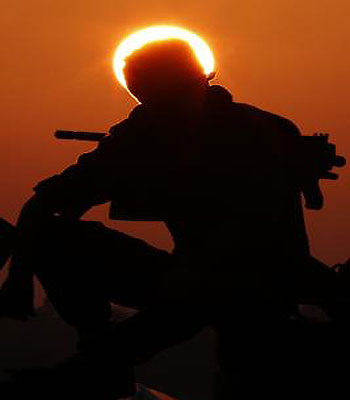 An Israeli soldier sits on top of a mobile artillery canon unit at an Israeli army deployment area near the Israel-Gaza Strip border on November 20, 2012. (AFP)