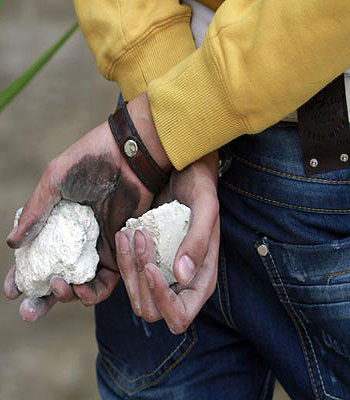 A Palestinian youth holds stones during clashes with Israeli forces near an Israeli army watch tower at the main entrance of the West Bank city of Bethlehem, as they protest against the ongoing Israeli offensive on the Gaza Strip. (AFP)