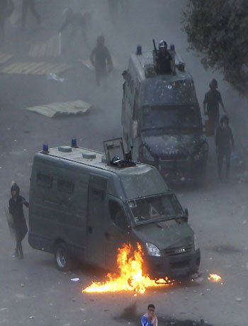 Flames burn around a police vehicle after protesters threw a molotov cocktail at it during clashes at Tahrir square in Cairo November 23, 2012. (Reuters)
