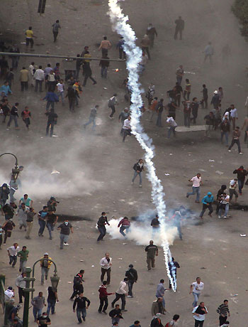 Protesters demonstrating against Egypt's Islamist President Mohamed Morsi run from tear gas fired by Egyptian riot police during clashes in Cairo's landmark Tahrir square on November 23, 2012. (AFP)