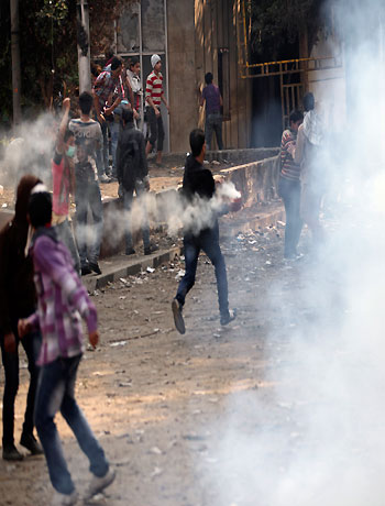 Egyptians clash with security forces and attempt to throw back tear gas canisters fired at them near Tahrir square n Cairo, Egypt, Tuesday, Nov. 27, 2012. (AP)