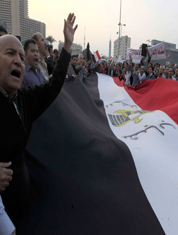 Anti-Mursi protesters chant anti-government slogans as they carry a large Egyptian flag at Tahrir Square in Cairo November 27, 2012. (Reuters)
