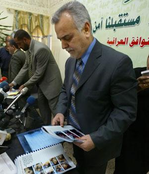 Tarek al-Hashimi, Secretary General of the Islamic Party in Iraq, looks at pictures of Iraqis who he said were tortured in detention centers across Iraq prior the start of his press conference in Baghdad, 16 November 2005 (AFP)