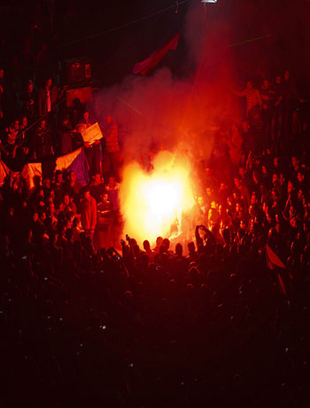 Egyptian protestors light up a flare during a demonstration in Cairo's Tahrir square against a decree by Egypt's President Mohamed Morsi granting himself broad powers that shield his decisions from judicial review on December 1, 2012. (AFP)