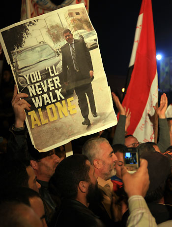 A supporter holds a newspaper picture of President Mohammed Morsi at a rally outside Cairo University in Cairo, Egypt, Saturday, Dec. 1, 2012. (AP)