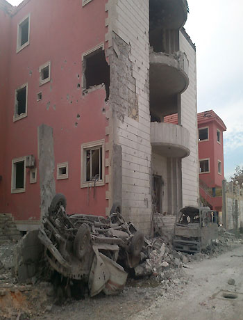 View of buildings damaged by what activists said were missiles fired by a Syrian Air Force fighter jet loyal to President Bashar al-Assad in the Akraba suburb of Damascus December 1, 2012. (Reuters)
