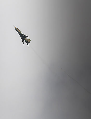 A Sukhoi-22 fighter jet of the Syrian air force drops flares after a bombing run in the town of Maraat al-Numan on November 17, 2012. (AFP)