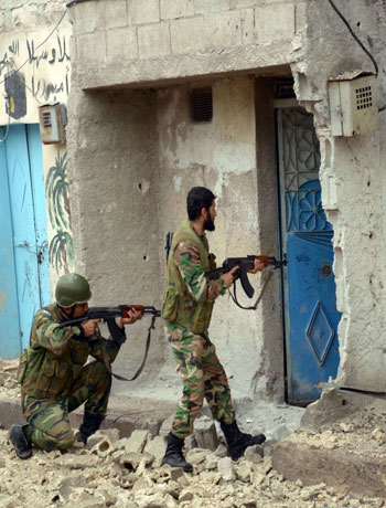 Syrian army soldiers patrol the Sheik Said neighbourhood of Syria's northern city of Aleppo on November 11, 2012, after they retook the area from opposition fighters. (AFP)