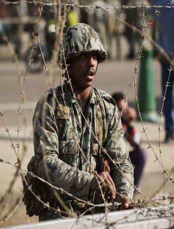 An Egyptian army soldier sets up barbed wire barricades outside of the Egyptian presidential palace in Cairo on December 6, 2012. (AFP)