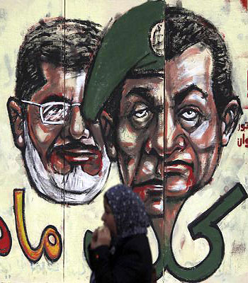 Anti-Mursi protester eats in front of graffiti on the wall of the presidential palace in Cairo. (R)