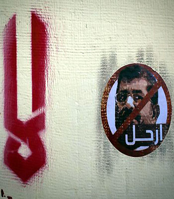 A sticker depicting Egyptian President Mohammed Mursi, with Arabic that reads "leave," is affixed to an outer wall of the presidential palace in Cairo, Egypt. (AP)